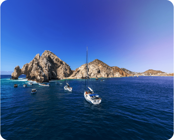 Tour boat near the iconic Arch of Cabo San Lucas with tourists on board