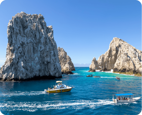 Tour boat near the iconic Arch of Cabo San Lucas with tourists on board